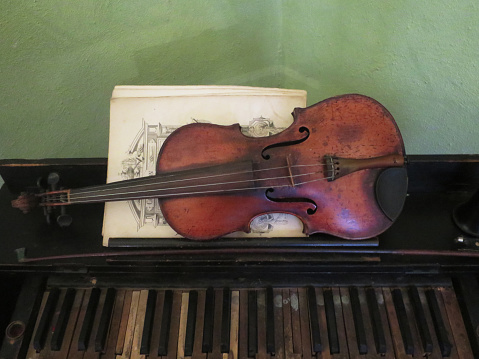 old violin on display with musical notes