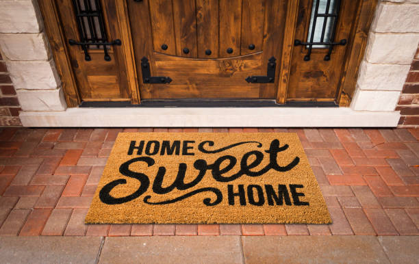 home sweet home willkommensmatte an der benutzerdefinierten haustür des hauses. - door mat stock-fotos und bilder