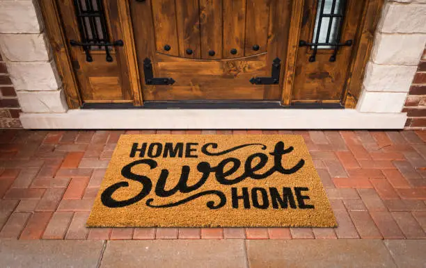 Photo of Home Sweet Home Welcome Mat At Custom Front Door of House.