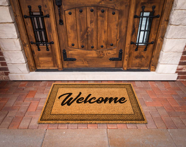 istock Welcome Mat At Custom Front Door Of House. 1360568105