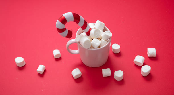 istock Chocolate cup with marshmallows on red background. Christmas hot sweet beverage 1360568343