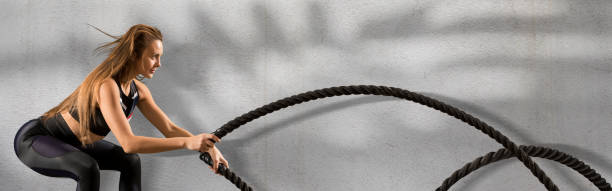 istock Woman working out with battle ropes 1360569997