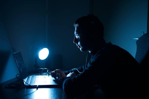 istock Young man working online on laptop at night 1360570132
