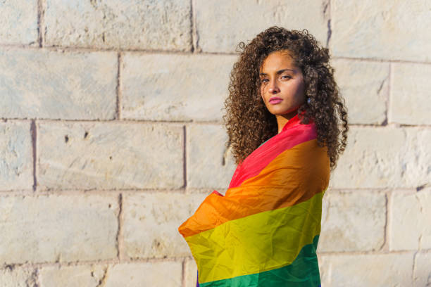 istock Curly haired woman with LGBT flag 1360572249