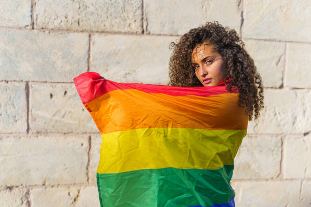 istock Curly haired woman with LGBT flag 1360572253