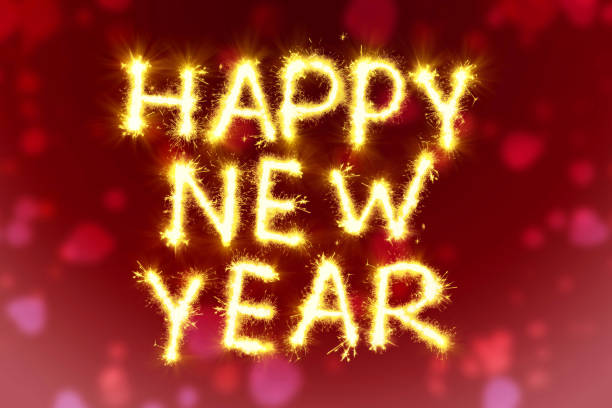 Happy New Year inscription on a background on a red toned background of from flashes of sparklers, candies from sparks. Festive lettering. Happy New Year inscription on a background on a red toned background of from flashes of sparklers, candies from sparks. Festive lettering new years day stock pictures, royalty-free photos & images