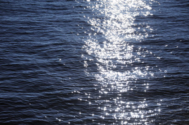 Trail of the sun glitters on the water. Abstract background or texture. Trail of the sun glitters on the water. Texture water background for design glittering sea stock pictures, royalty-free photos & images