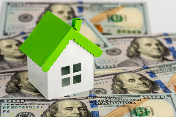 istock One hundred dollars banknotes with mini model house. 1360575757