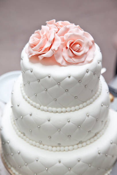 istock a multi level white wedding cake and pink flowers on top. Big cake. 1360576732