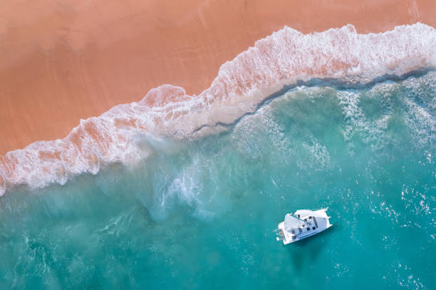 istock Sailboating next to the beach with waves crashing 1360580259
