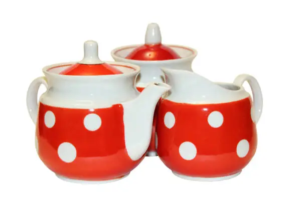 Red tea set. Teapot, sugar bowl, milk jug. Close-up. Side view. The isolated object on a white background. Isolate.