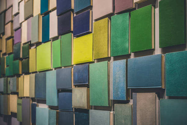 Many books creating feeling of wallpaper attached to a wall. Colorful empty covers