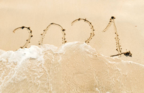 istock handwritten inscription 2021 on the sand 1360586559
