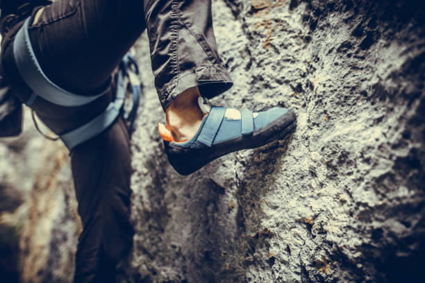 Person climbing while wearing rock climbing shoes stock photo