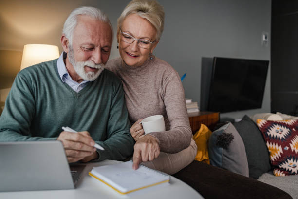 istock Senior couple at home, using laptop 1360588946