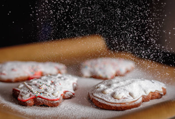 Sprinkle icing sugar over the Christmas cookies.