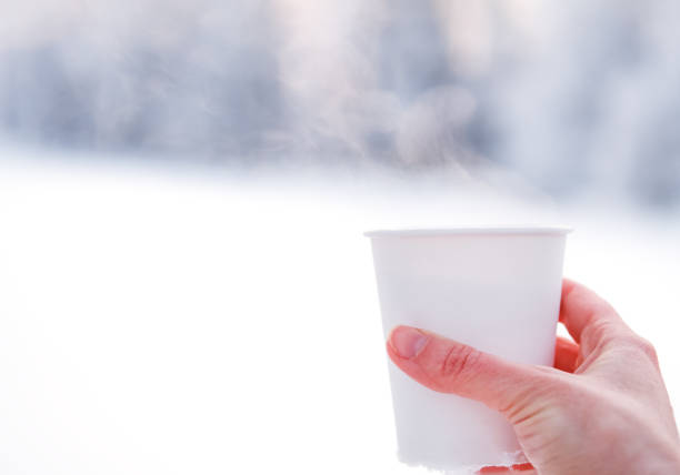 istock White paper cup with hot tea on snowy table. 1360590732