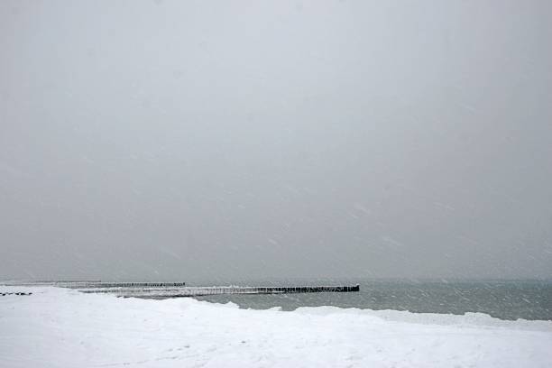 istock Snow and ice covered groynes at ocean front 1360592486