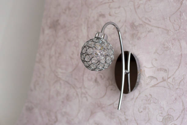 istock Round sconce made of crystals on pink wall 1360592640