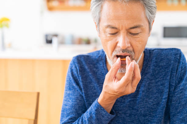 istock elderly man takes medicine capsules 1360603281