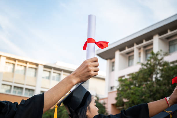 istock graduates wearing black hats holding university graduation certificates,Concept education congratulation. Graduation Ceremony ,Congratulated the graduates in University. 1360618372