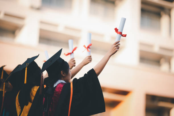 istock graduates wearing black hats holding university graduation certificates,Concept education congratulation. Graduation Ceremony ,Congratulated the graduates in University. 1360618376