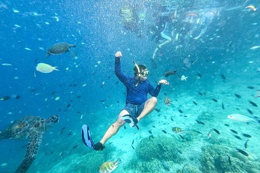 asian man snorkeling at coral reef