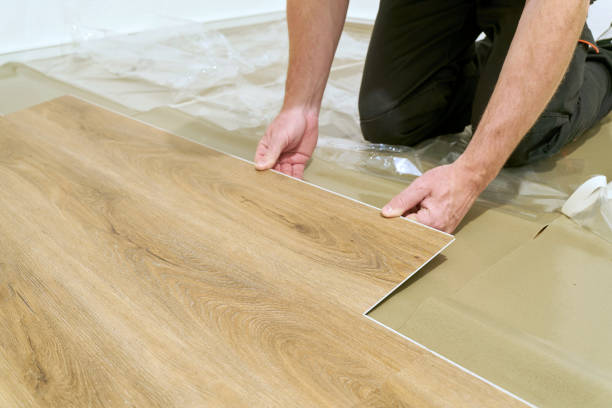 Laying click vinyl flooring by a craftsman stock photo