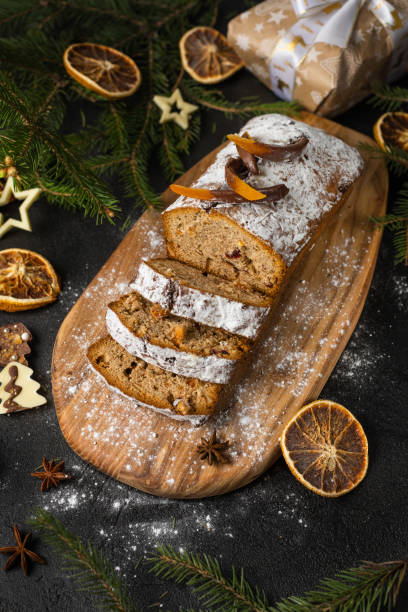 istock Christmas cake with nuts and dried fruits sliced on a board 1360624720