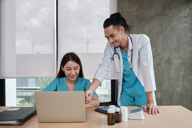 istock Two uniformed young doctors work in medical clinic office. 1360625713