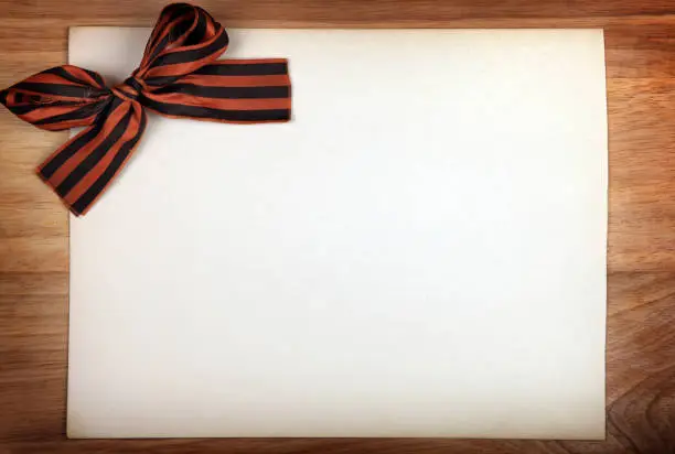 Ribbon of Saint George on Blank Paper and Wooden Background