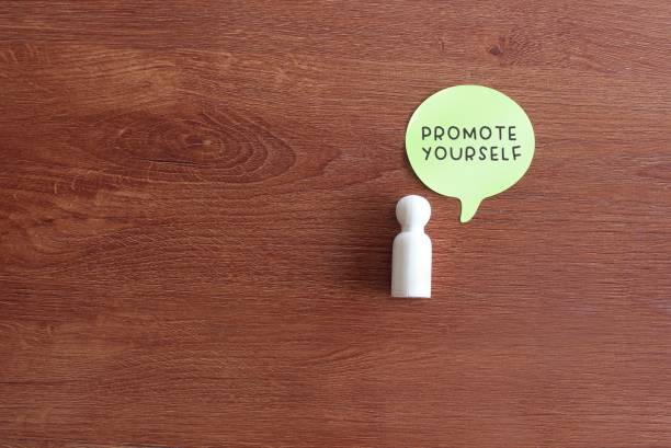 istock Wooden doll and speech bubble with text PROMOTE YOURSELF 1360634683