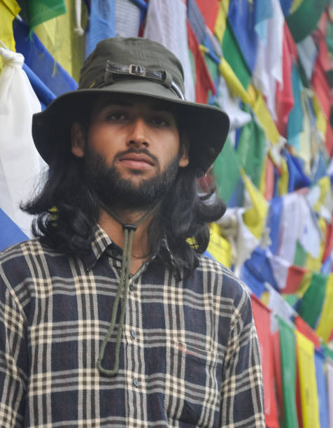 istock A bearded and long haired male tourist  looking at camera while standing against Buddhist prayer flags 1360635289