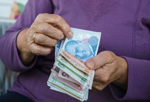 Mujer jubilada contando liras turcas en casa, de cerca photo