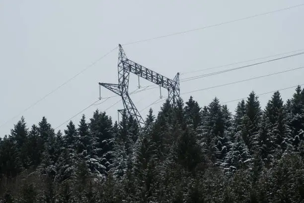 Winter view of a high voltage pylon in the mountains of Vosges in France, covered with snow in december. Possible power blackout planned for december and january.