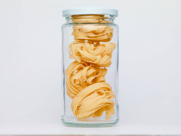 istock Pasta in glass jar on a white background 1360641641