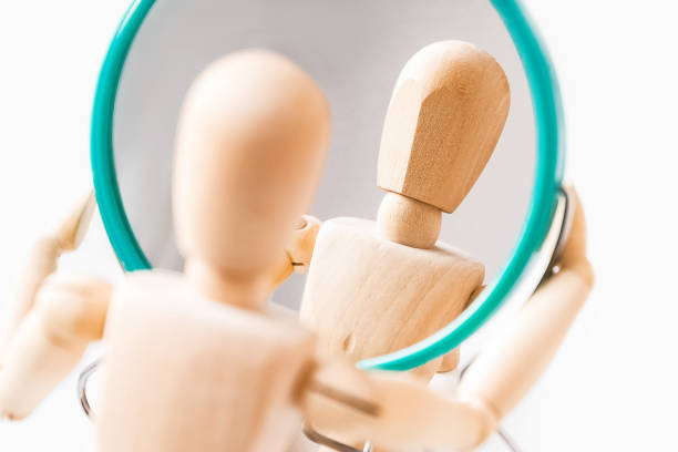 istock Wooden dummy looks at its reflection in the mirror 1360641661