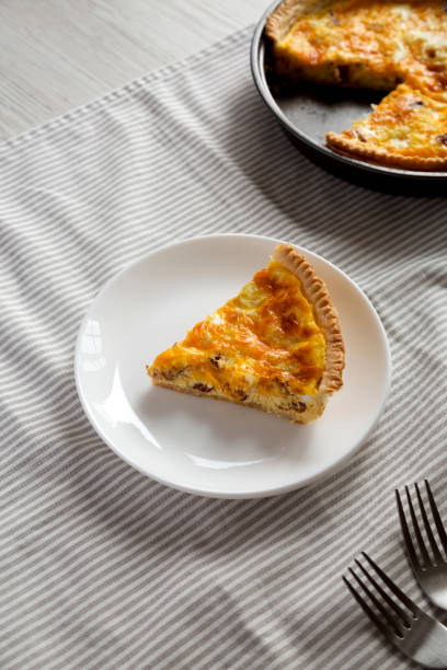 istock Homemade Bacon Quiche with Eggs and Cheddar Cheese on a white plate, high angle view. 1360642991