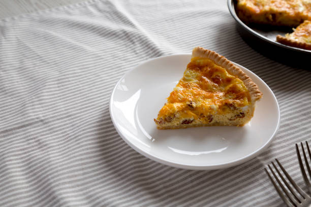 istock Homemade Bacon Quiche with Eggs and Cheddar Cheese on a white plate, side view. Copy space. 1360643008