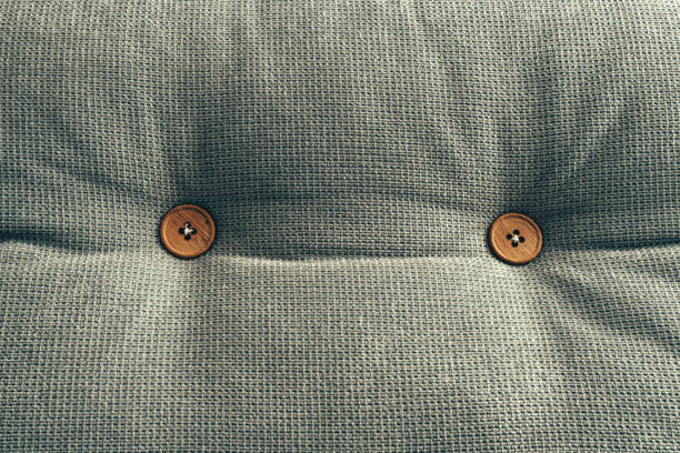 Bed cushion with wooden buttons as background, home interior decoration