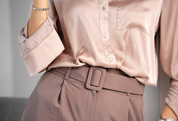 Classic business style of clothing. Palazzo trousers with a wide belt and a silk blouse. Powdery pink color. A combination of shades of color in clothing. blouse stock pictures, royalty-free photos & images