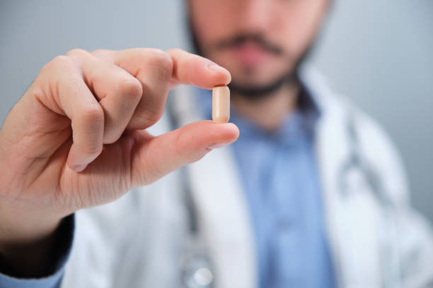 istock Unrecognizable doctor holding a pill. 1360649198
