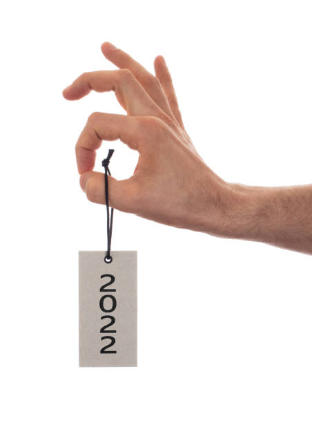 istock Hand holding a tag - New year - 2022 1360651781