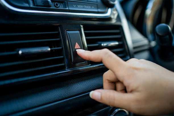 istock Close up hand press the emergency light in the car. Emergency button press for open emergency light warning sign symbol out side car 1360652084