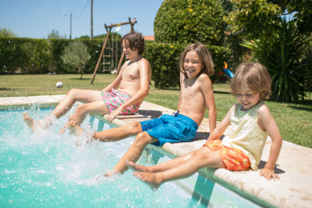 istock Happy brothers having fun near swimming pool 1360653064
