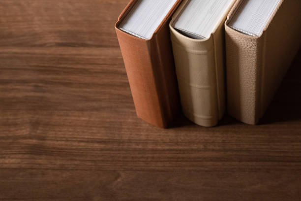 колючки книг в кожаных твердых обложках на деревянном фоне - book spine book old in a row стоковые фото и изображения