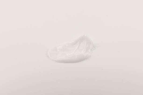 istock White smear of cosmetic cream isolated on light background. 1360656050
