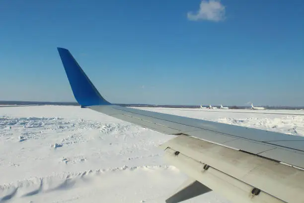 Photo of Landing aircraft at the airport. Deceleration of the aircraft on the runway. The wing of the plane is in working order. View from the porthole. Close-up. Background.