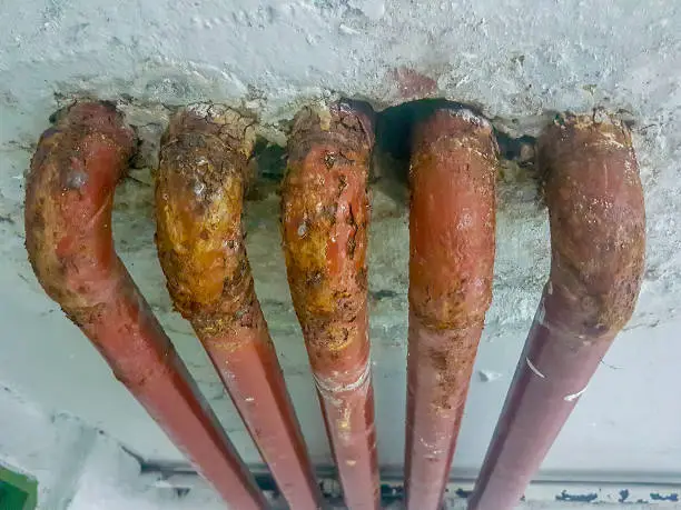 Photo of several old lead pipes in a wall