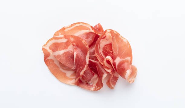 prosciutto crudo italiano o jamón. jamón crudo. aislado sobre fondo blanco. - jamón de parma fotografías e imágenes de stock